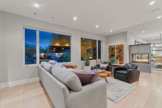 Living area with light wood-style floors, recessed lighting, a multi sided fireplace, and baseboards | Image 7