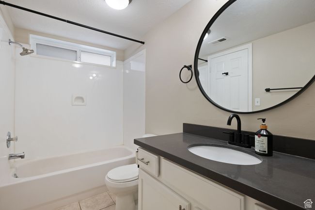 Full bathroom featuring visible vents, toilet, vanity, tile patterned floors, and washtub / shower combination | Image 19