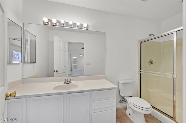 Bathroom with a shower stall, vanity, and tile patterned flooring | Image 16