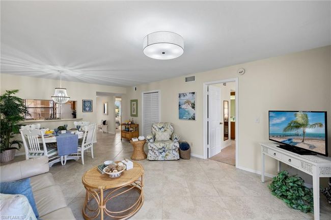 Living room featuring light tile patterned flooring and a chandelier | Image 6