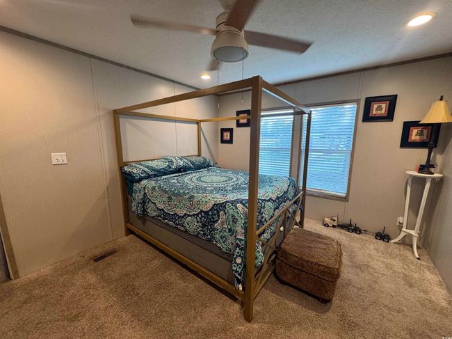 Carpeted bedroom featuring a ceiling fan, a textured ceiling, a decorative wall, and recessed lighting | Image 10