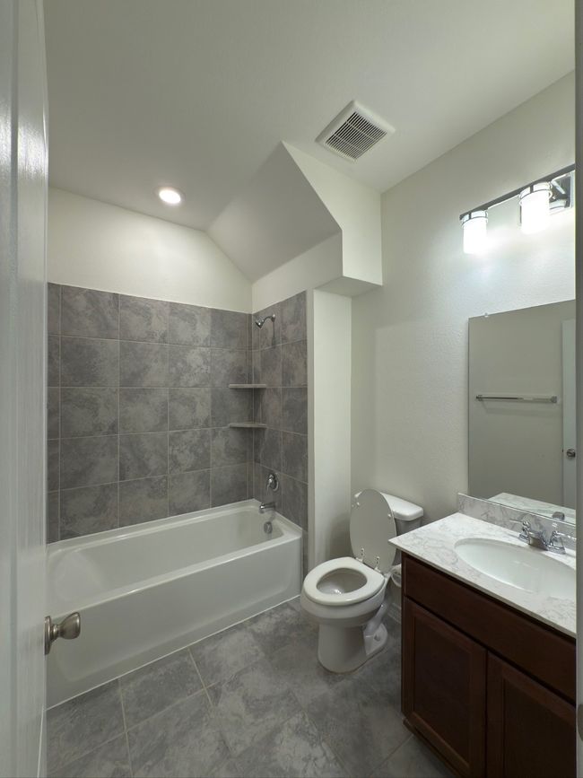 Full bathroom featuring vanity, shower / tub combination, and tile patterned floors | Image 25
