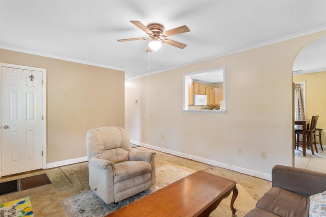 Living room with ceiling fan, crown molding, and wood finished floors | Image 13