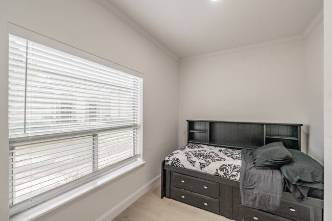 Bedroom featuring baseboards, crown molding, wood finished floors, and multiple windows | Image 4
