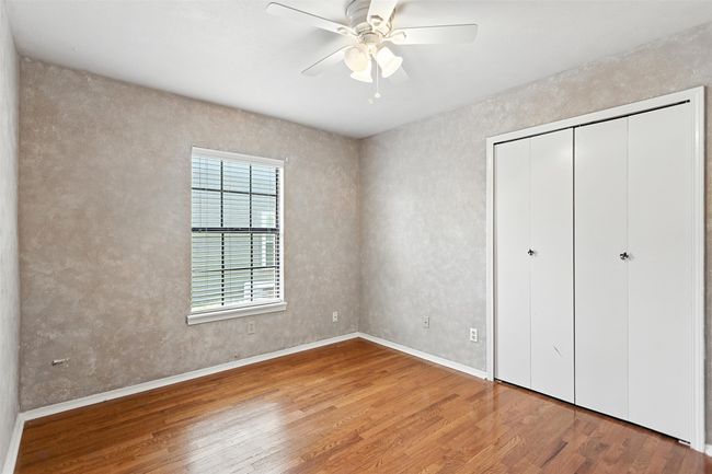Unfurnished bedroom with wood finished floors, a closet, and a ceiling fan | Image 8