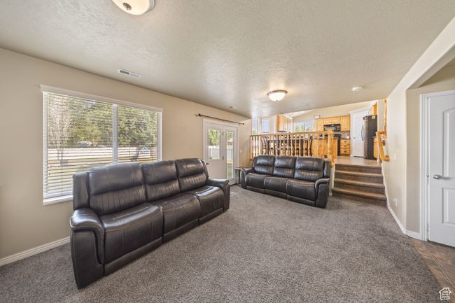 Living room featuring a textured ceiling and dark carpet | Image 13