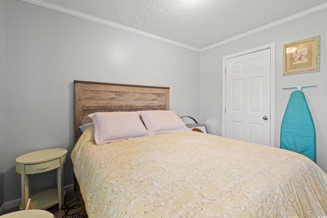 Bedroom featuring crown molding and a textured ceiling | Image 26
