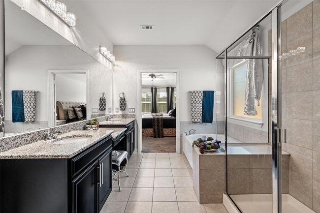 Bathroom with a stall shower, tile patterned floors, ensuite bath, visible vents, and lofted ceiling | Image 19