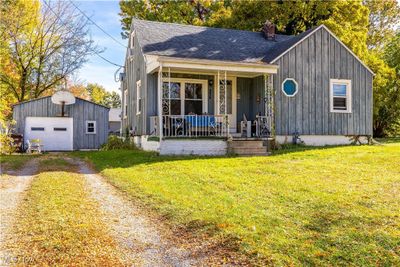 View of front facade with a front yard, a porch, an outbuilding, and a garage | Image 3