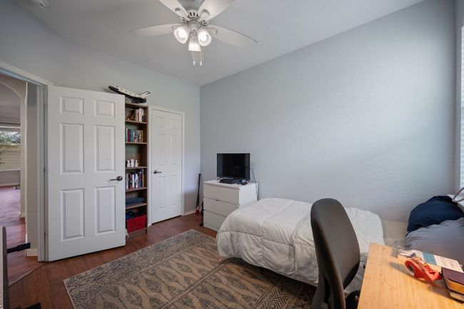 Bedroom with wood finished floors, ceiling fan, baseboards, and arched walkways | Image 23