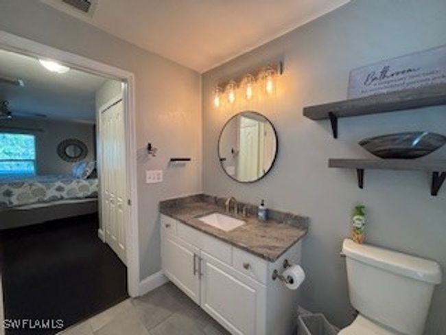 Bathroom featuring visible vents, baseboards, toilet, vanity, and ensuite bath | Image 17
