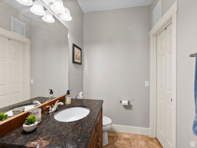 Private bathroom (adjacent to main floor bedroom) with baseboards, vanity, and toilet | Image 13