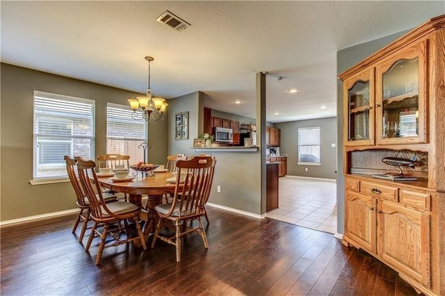 Dining area featuring a chandelier, dark wood-style floors, and recessed lighting | Image 4