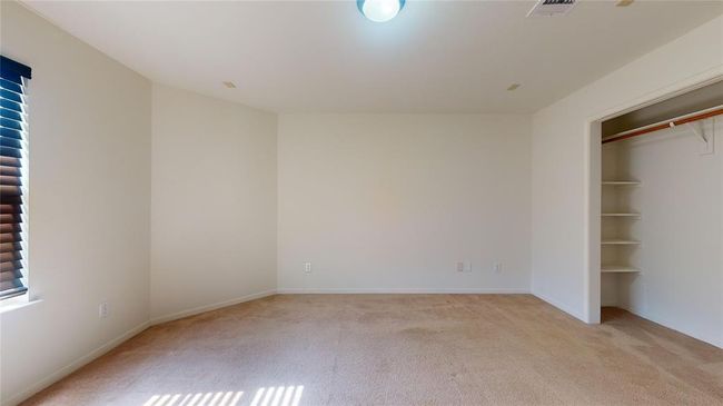 Bright guest bedroom featuring three large windows for ample natural light. | Image 35