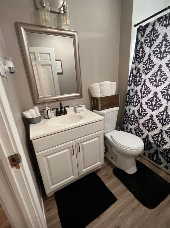 Full bathroom with toilet, vanity, a shower with curtain, and wood finished floors | Image 5