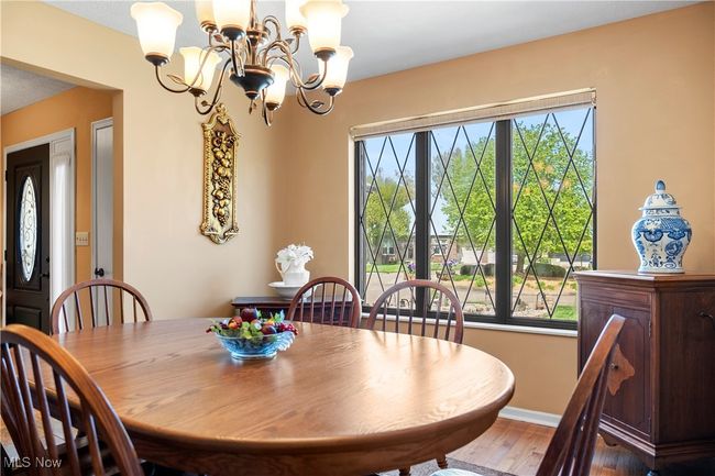 Dining room with a chandelier, wood finished floors, and baseboards | Image 10