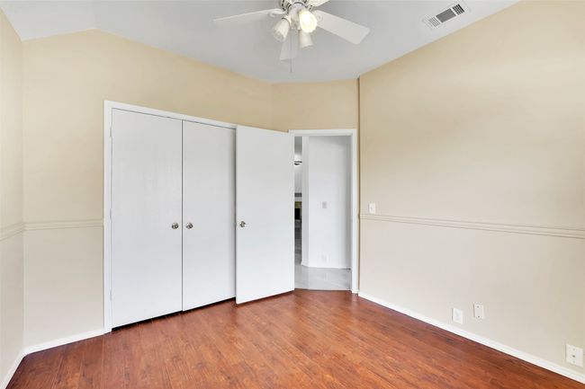 Unfurnished bedroom with a closet, wood-type flooring, ceiling fan, and vaulted ceiling | Image 15