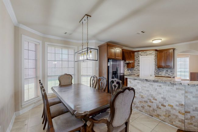 Dining room with arched walkways, a wealth of natural light, and light tile patterned floors | Image 8