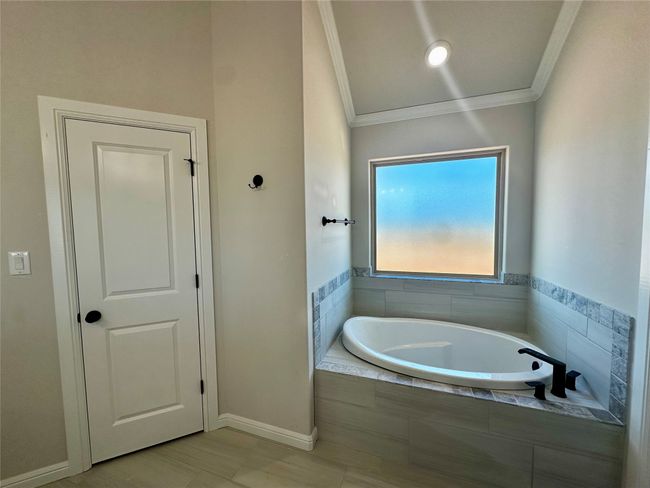 Full bath with a garden tub, baseboards, and crown molding | Image 17