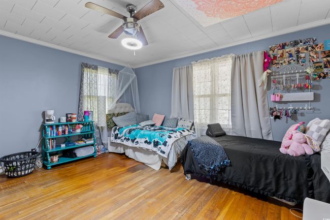Bedroom with crown molding, wood finished floors, and ceiling fan | Image 28