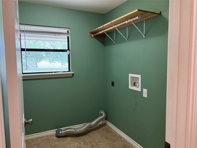 Laundry area featuring hookup for an electric dryer, hookup for a washing machine, and baseboards | Image 14