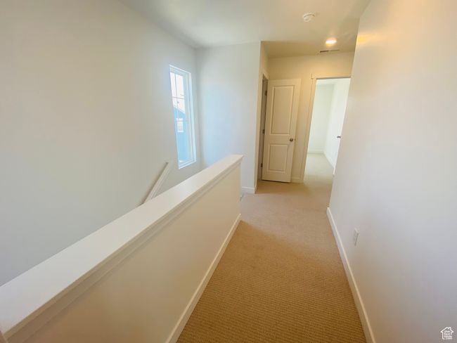 Hall with light colored carpet and an upstairs landing | Image 11