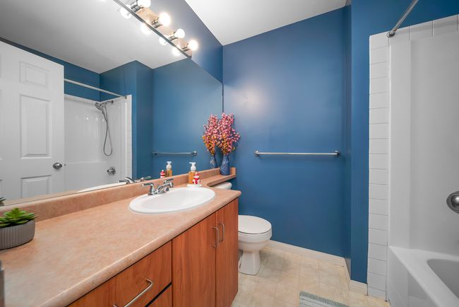 Bathroom featuring tile patterned floors, toilet, vanity, tub / shower combination, and baseboards | Image 33