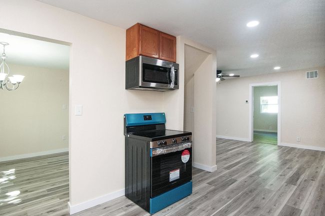 Kitchen featuring appliances with stainless steel finishes, a chandelier, light wood-style flooring, recessed lighting, and ceiling fan | Image 11