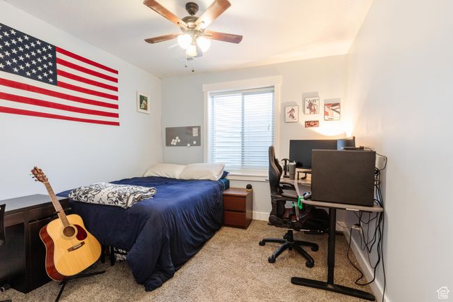 Carpeted bedroom featuring an office area and a ceiling fan | Image 37