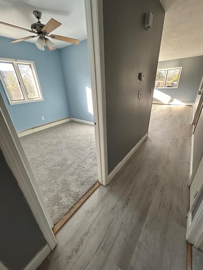 Hallway featuring baseboard heating, light hardwood / wood-style flooring, and a wealth of natural light | Image 18