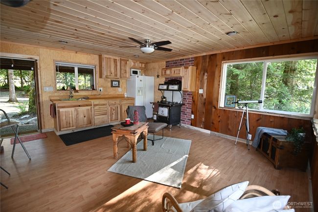 Warm & inviting 1 bdrm, half bath. Featuring cozy bar seating, a classic wood stove, an antique gas stove, and overhead LED lighting w/remote controlled fan. | Image 14