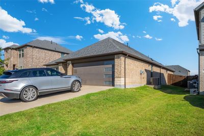 View of side of property with central AC unit, a garage, and a yard | Image 2