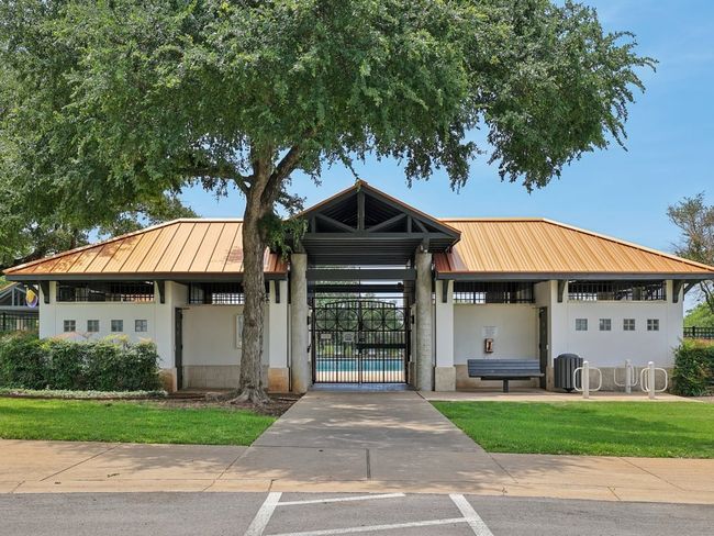 View of building exterior featuring an outdoor pool, fence, and central air condition unit | Image 33