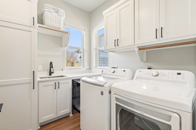 Laundry area featuring cabinet space, washer and dryer, and light wood-style flooring | Image 25
