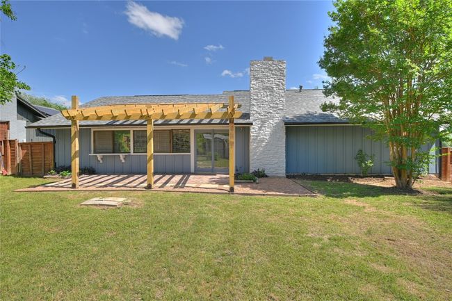 Back of house with board and batten siding, a pergola, a patio area, and a shingled roof | Image 19