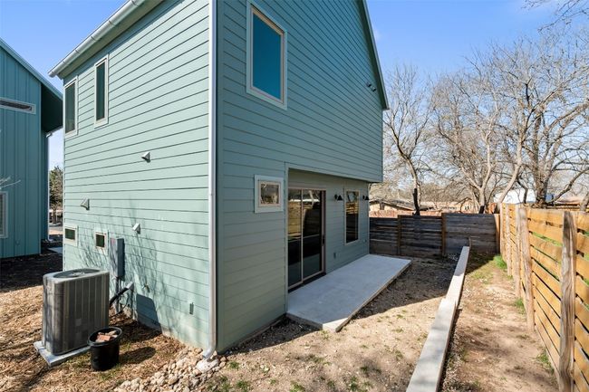 Back of property with central air condition unit, a patio area, and a fenced backyard | Image 32