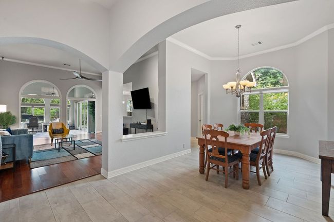 Dining room with wood finished floors, visible vents, ornamental molding, and a healthy amount of sunlight | Image 11