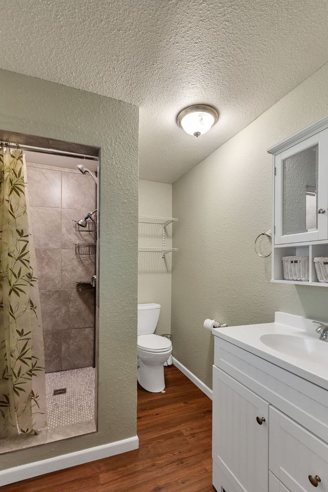 Bathroom featuring a shower stall, vanity, dark wood finished floors | Image 13