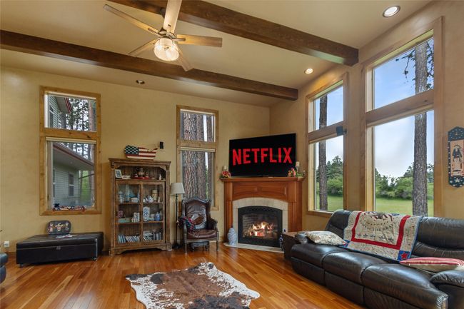Living room with beamed ceiling, hardwood / wood-style flooring, a tile fireplace, a ceiling fan, and recessed lighting | Image 10