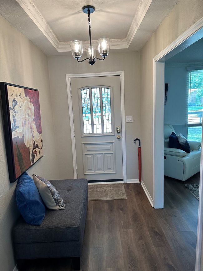 Foyer entrance with a chandelier, dark wood-style flooring, a tray ceiling, ornamental molding, and baseboards | Image 12