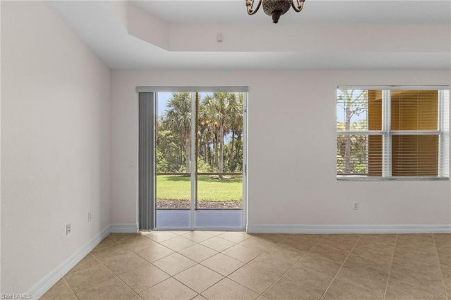Empty room featuring light tile patterned floors and a chandelier | Image 12