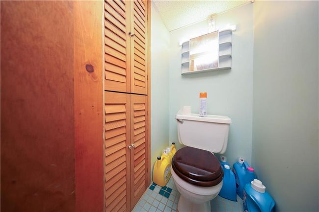 Bathroom with a closet and a textured ceiling | Image 26