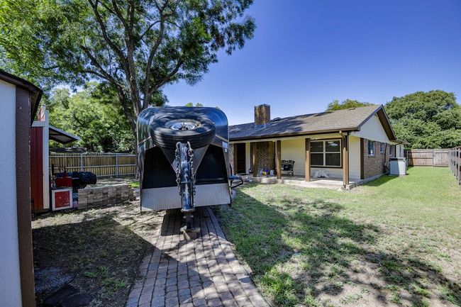 Back of house featuring brick siding, a patio, a chimney, and a fenced backyard | Image 25