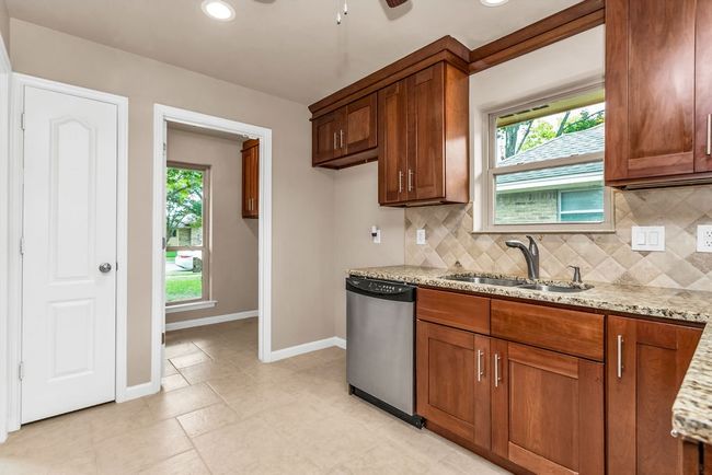 Kitchen with stainless steel dishwasher, light stone countertops, decorative backsplash, brown cabinets, and recessed lighting | Image 9