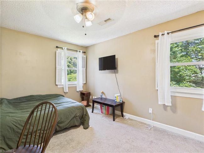 Bedroom with lots of natural light and serene views of the back yard. | Image 24