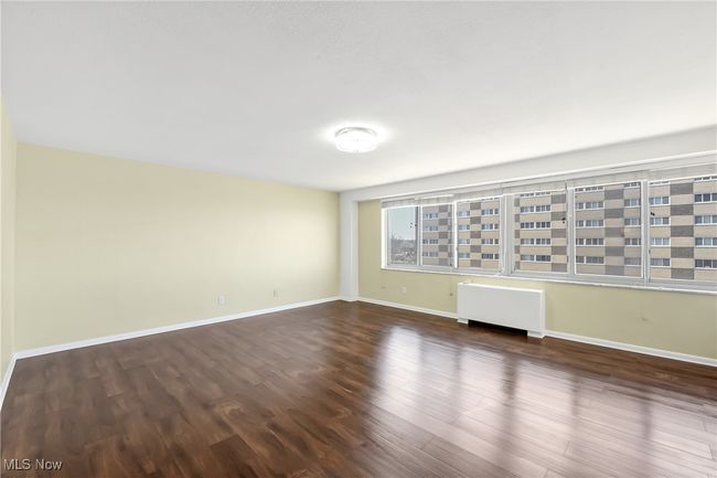 Unfurnished room featuring baseboards, wood finished floors, and radiator heating unit | Image 22