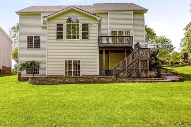 Rear view of property featuring a lawn, a wooden deck, and stairs | Image 5