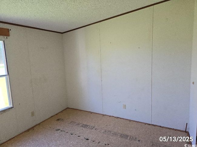 Empty room featuring crown molding and a textured ceiling | Image 33