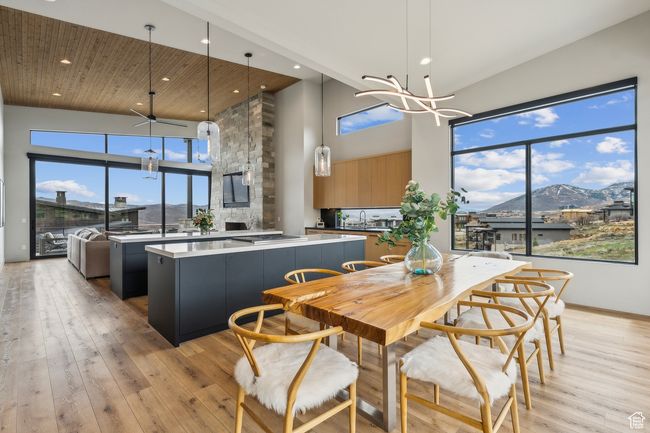 Dining space with a notable chandelier, light wood-style flooring, a towering ceiling, and recessed lighting | Image 27