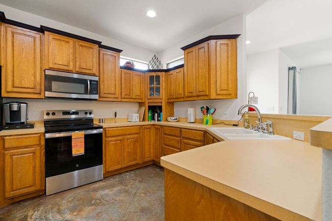 A kitchen that knows how to work hard and look good doing it—with stainless steel appliances, tons of cabinetry, and classic, easy-care finishes. | Image 5